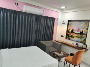a bedroom with a bed and a desk and a chair at Lilium Hotels in Chākan