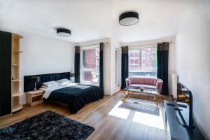 een woonkamer met een bed, een stoel en een bank bij Cosmo Apartments in Gdańsk