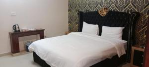 a bedroom with a large bed with a black headboard at City Home Guest House F8-3 in Islamabad +28 photos
