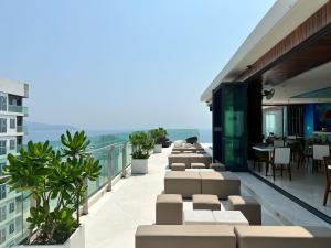 ein Balkon mit Stühlen und Tischen an einem Gebäude in der Unterkunft COZY Studio in A La Carte Da Nang in Đà Nẵng