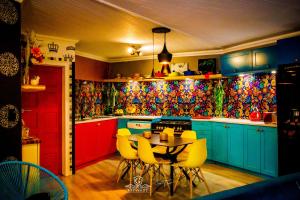 a kitchen with colorful cabinets and a table with yellow chairs at Gypsy Guest House Clarens in Clarens