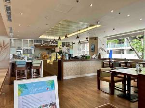 ein Restaurant mit Tischen und Stühlen und einer Theke in der Unterkunft COZY Studio in A La Carte Da Nang in Đà Nẵng