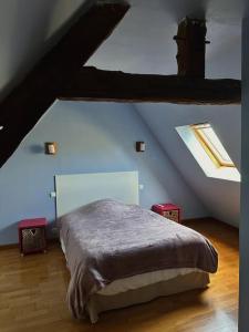 a bedroom with a bed in a attic at Maison entre Rennes et St-Malo in Saint-Pierre-de-Plesguen