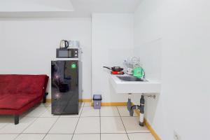 タンゲランにあるSimple and Comfort Design 2BR Apartment at M Town Residence By Travelioのキッチン(シンク、赤いソファ付)