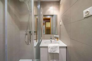 ein weißes Badezimmer mit Dusche und Waschbecken in der Unterkunft Arcelle Condo by Alpstays in Val Thorens