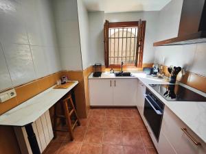 a small kitchen with white counters and a window at Casa Cincilia in Chinchilla de Monte Aragón