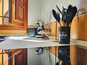 a kitchen counter with a container of cooking utensils at Casa Cincilia in Chinchilla de Monte Aragón