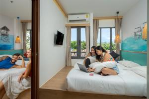a group of people sitting on beds in a hotel room at Lub d Siem Reap - Near Pub Street & Angkor Wat in Siem Reap
