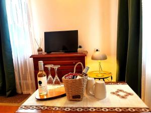 a table with a bottle of wine and a television at Dvata Smurcha Central Apartments - Free Parking in Bansko