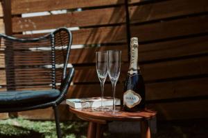un tavolo con due bicchieri e una bottiglia di champagne di Coles on James a Devonport