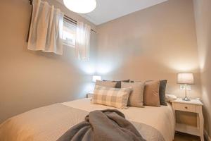 a bedroom with a bed and two lamps and a window at Alya parking incluido in Sierra Nevada +42 photos