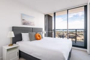 una camera da letto con un letto grande e una grande finestra di Melbourne Corporate Stays - Docklands Waterfront a Melbourne Altre 37 foto