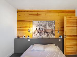 a bedroom with a bed and a picture of deer at Magnifique Chalet Moderne Familial in Font Romeu Odeillo Via