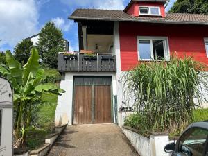 a red and white house with a wooden door at Ferienwohnung in Alpirsbach in Alpirsbach