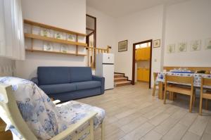 a living room with a blue couch and a table at Villa Negri in Lignano Sabbiadoro