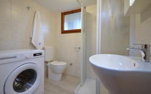 a bathroom with a washing machine and a sink at Villa Negri in Lignano Sabbiadoro