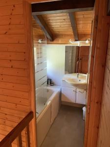 a bathroom with a tub and a sink at Chalet 151Nabor in Les Gets