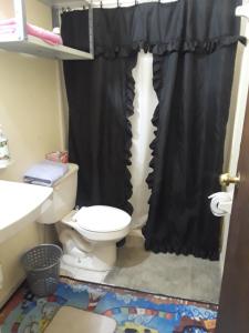 a bathroom with a toilet and a black shower curtain at La esquina in Monterrey +5 photos