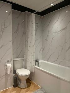 a bathroom with a toilet and a bath tub and a sink at Eldridge Court Apartment - 1 bedroom in Dagenham