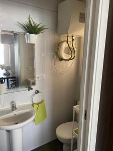 un bagno con lavandino, WC e specchio di Casa Bella Apartment BY NAMASTE ELITE a Torremolinos