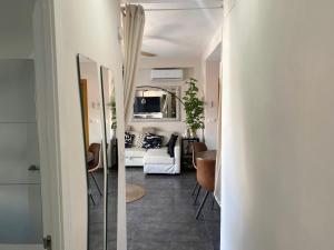 un soggiorno con divano bianco e specchio di Casa Bella Apartment BY NAMASTE ELITE a Torremolinos