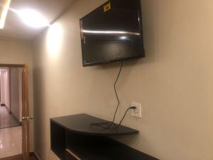 Un televisor de pantalla plana colgado en una pared en Al Buraq Hotel, en Islamabad 11 fotos más