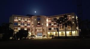 a large building at night with the moon behind it at Sagar Resort in Alwar