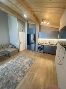 a large living room with a couch and a kitchen at winter house GUDAURI in Gudauri