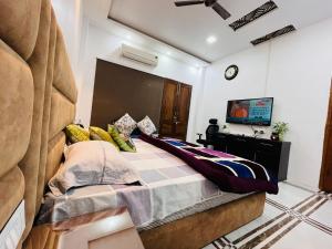 a bedroom with a bed and a tv in it at Shreshth Home Stay - Best Family Accommodation - 3km from Har Ki Pauri, Haridwar, Uttarakhand in Haridwār