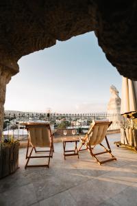 a patio with two chairs and a table and a view at Paradise Cappadocia Hotel & Rooftop in Göreme