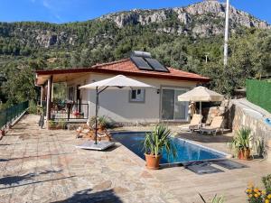 a villa with a swimming pool and a house at Magnificent sunset view in Fethiye