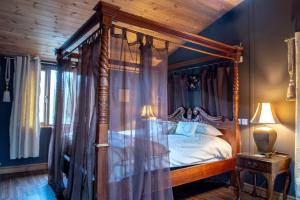 a bedroom with a canopy bed with a wooden ceiling at Beveren Lodge in Selby