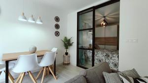 a dining room with a table and chairs and a bedroom at Apartamento Bellaluz 0505 Resort Golf La Manga Club in Cartagena