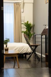 a room with a bed and a table with a plant at Nagomi Gokoro Village Shin-Osaka in Osaka