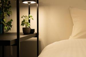 a bedroom with a bed and a plant on a shelf at Nagomi Gokoro Village Shin-Osaka in Osaka