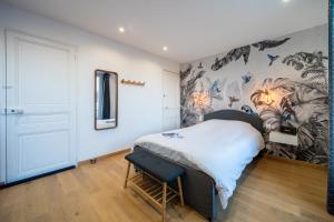 a bedroom with a bed and a painting on the wall at Appart 2 personnes à 50m des commerces & mer in Barneville-Carteret
