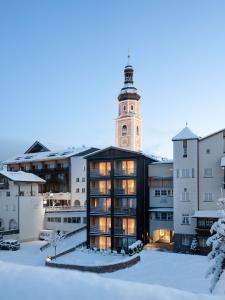 a building with a clock tower in the snow at Lamondis in Castelrotto
