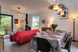 a living room with a table and a red couch at Grande maison bord de Mer in Sarzeau