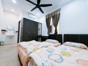 a bedroom with two beds and a ceiling fan at Trace Cozy Place in Teluk Intan