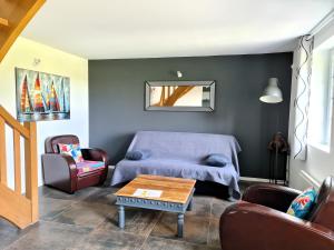 un soggiorno con un divano e un tavolo di Maison normande a Freneuse-sur-Risle