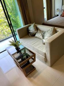 a living room with a couch and a coffee table at Apartment in Mida Grande Surin in Ban Lum Fuang