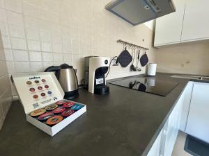 una encimera de cocina con cafetera y una caja de donuts en Urban Sky Loft Fiumicino, en Fiumicino