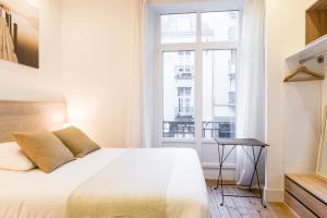 a bedroom with a large bed and a window at Unsejouranantes - Gîte Lamoricière in Nantes
