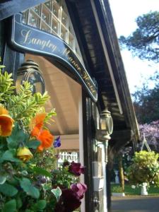 a sign on the side of a building with flowers at Langtry Manor Hotel in Bournemouth