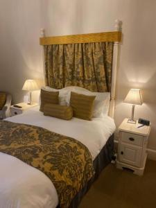 a hotel room with a bed and two lamps at Langtry Manor Hotel in Bournemouth