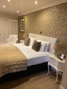 a bedroom with a large bed with white pillows at Langtry Manor Hotel in Bournemouth