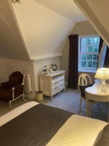 a bedroom with a bed and a desk and a chair at Langtry Manor Hotel in Bournemouth