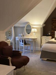 a bedroom with a bed and a desk with a mirror at Langtry Manor Hotel in Bournemouth