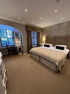 a large bedroom with a large bed and a desk at Langtry Manor Hotel in Bournemouth