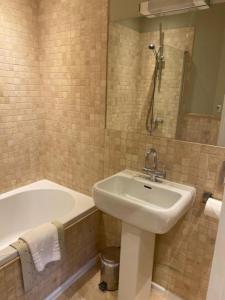 a bathroom with a sink and a bath tub and a sink at Langtry Manor Hotel in Bournemouth